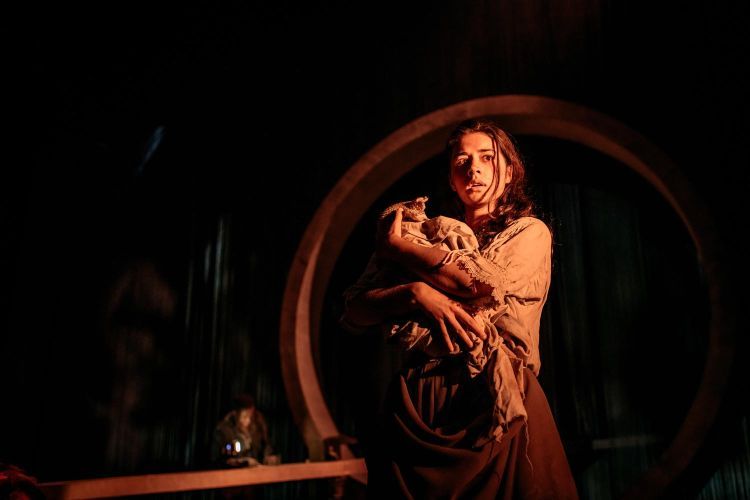Actor holding a fake baby on the set of The Wheel